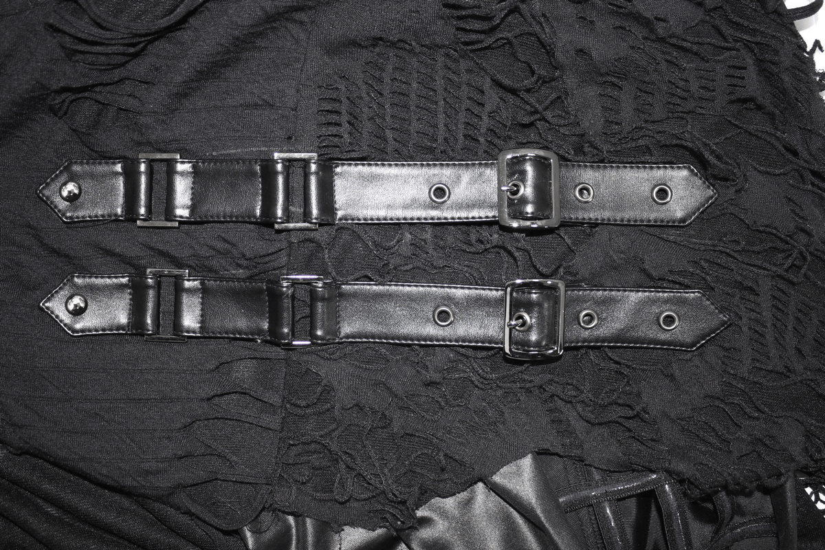 Close-up of stylish black straps with buckles on layered gothic clothing fabric.