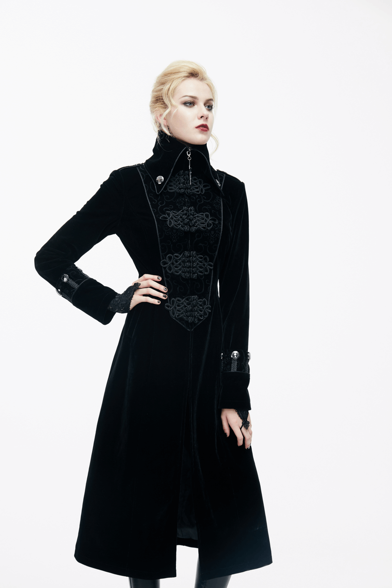 Elegant woman modeling a long black gothic coat with stand-collar and intricate jacquard detailing.