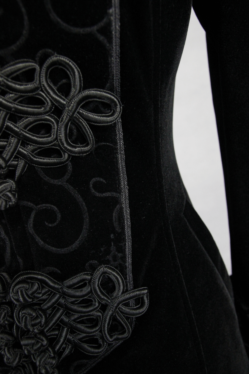 Close-up of intricate black velvet detailing on a gothic style women's coat, showcasing unique textures and patterns.