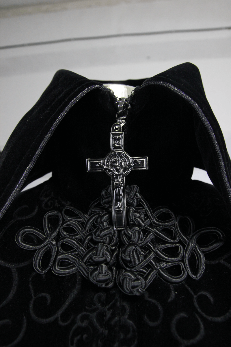 Close-up of a gothic black coat collar featuring intricate embroidery and a decorative cross zipper.
