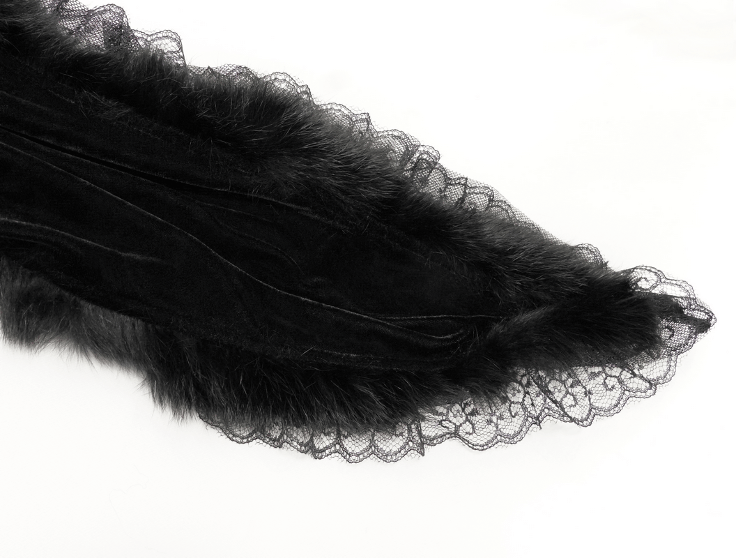 Close-up of black velvet fabric with fur and lace detailing, perfect for a Gothic-style dress.