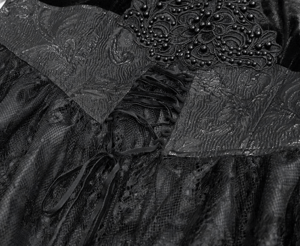Close-up of gothic long black dress with intricate fabric details and lace-up design, showcasing luxury and vintage elegance.