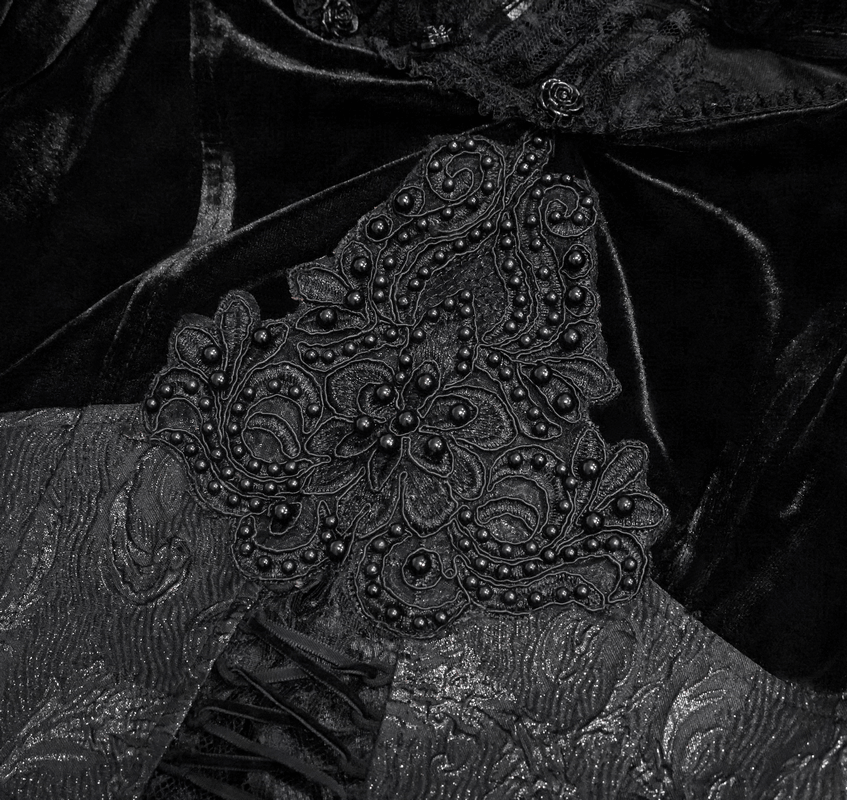 Close-up of luxurious gothic black dress fabric with intricate bead and floral embroidery details.