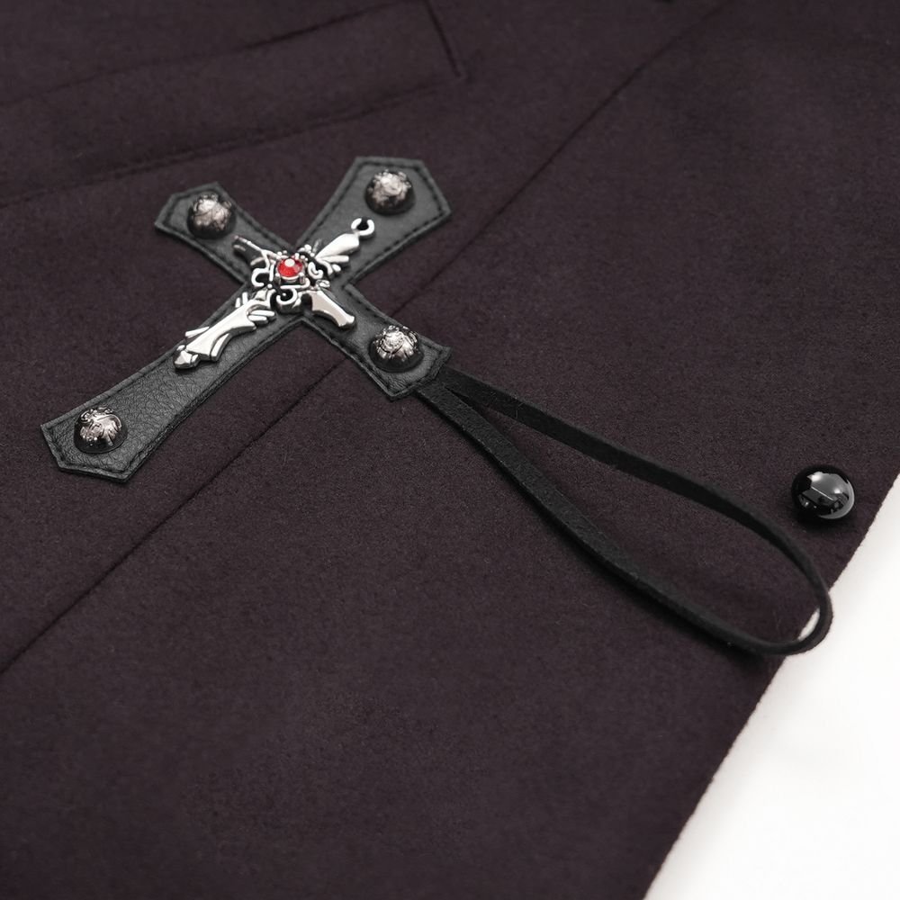 Close-up of silver cross buckle on dark gothic women's coat with faux fur trim.