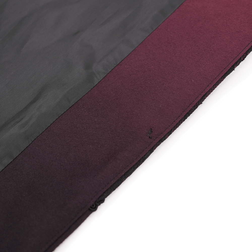 Close-up of black and burgundy fabric from inside a women's coat, showcasing exquisite craftsmanship and rich color.