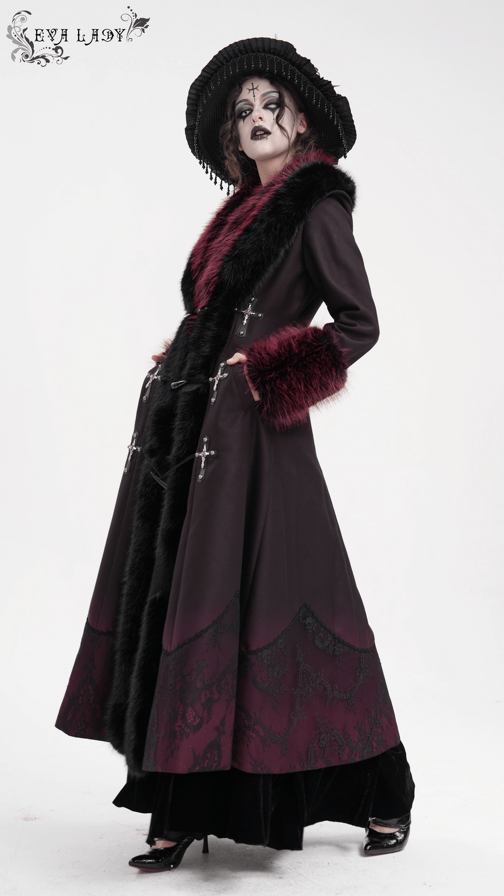 Gothic women's long coat with faux fur trim and cross buckles, featuring a dark A-line design with plush collar and cuff accents.