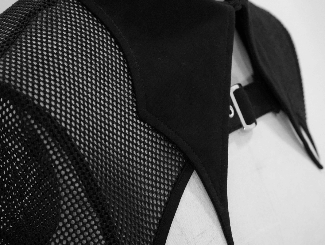 Close-up of a punk gothic black mesh crop top featuring a stylish collar and buckle detail.