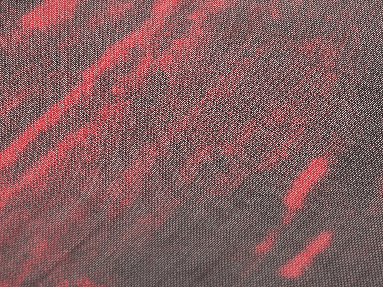 Close-up of bold red and black sheer mesh fabric, showcasing a grunge aesthetic perfect for edgy fashion.