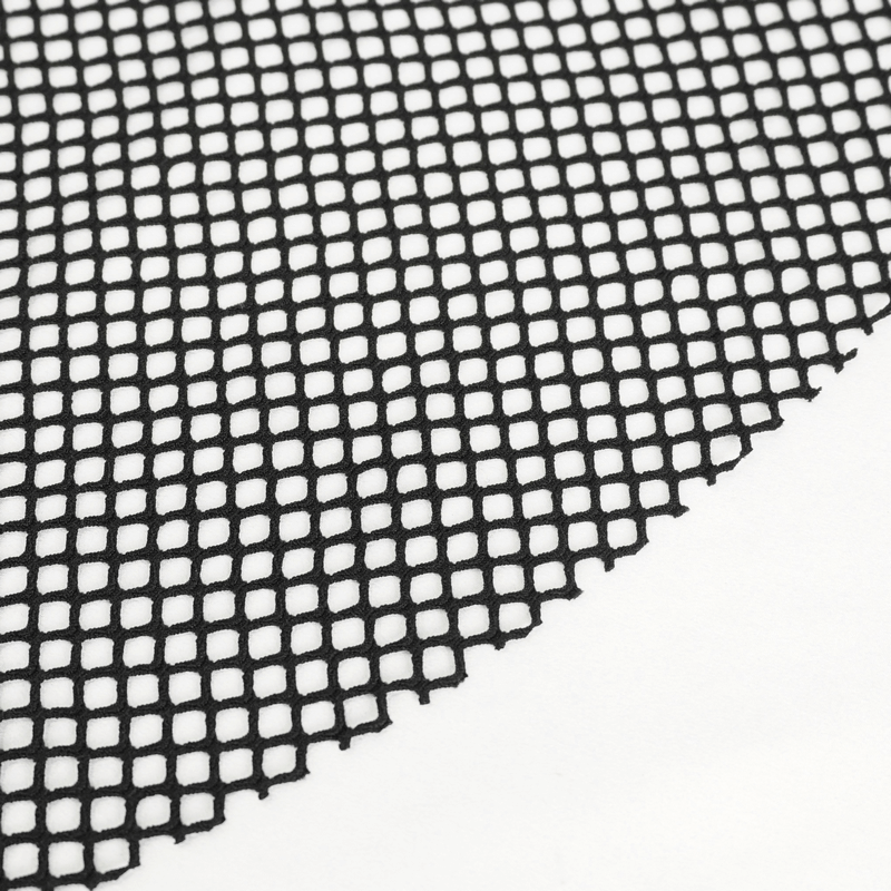 Close-up of black mesh fabric with diamond grid pattern, highlighting texture for gothic-style flared pants.