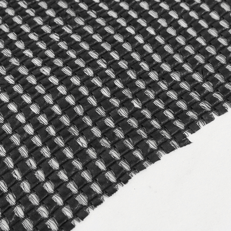 Close-up of black mesh fabric, showcasing woven texture ideal for fashionable garments.