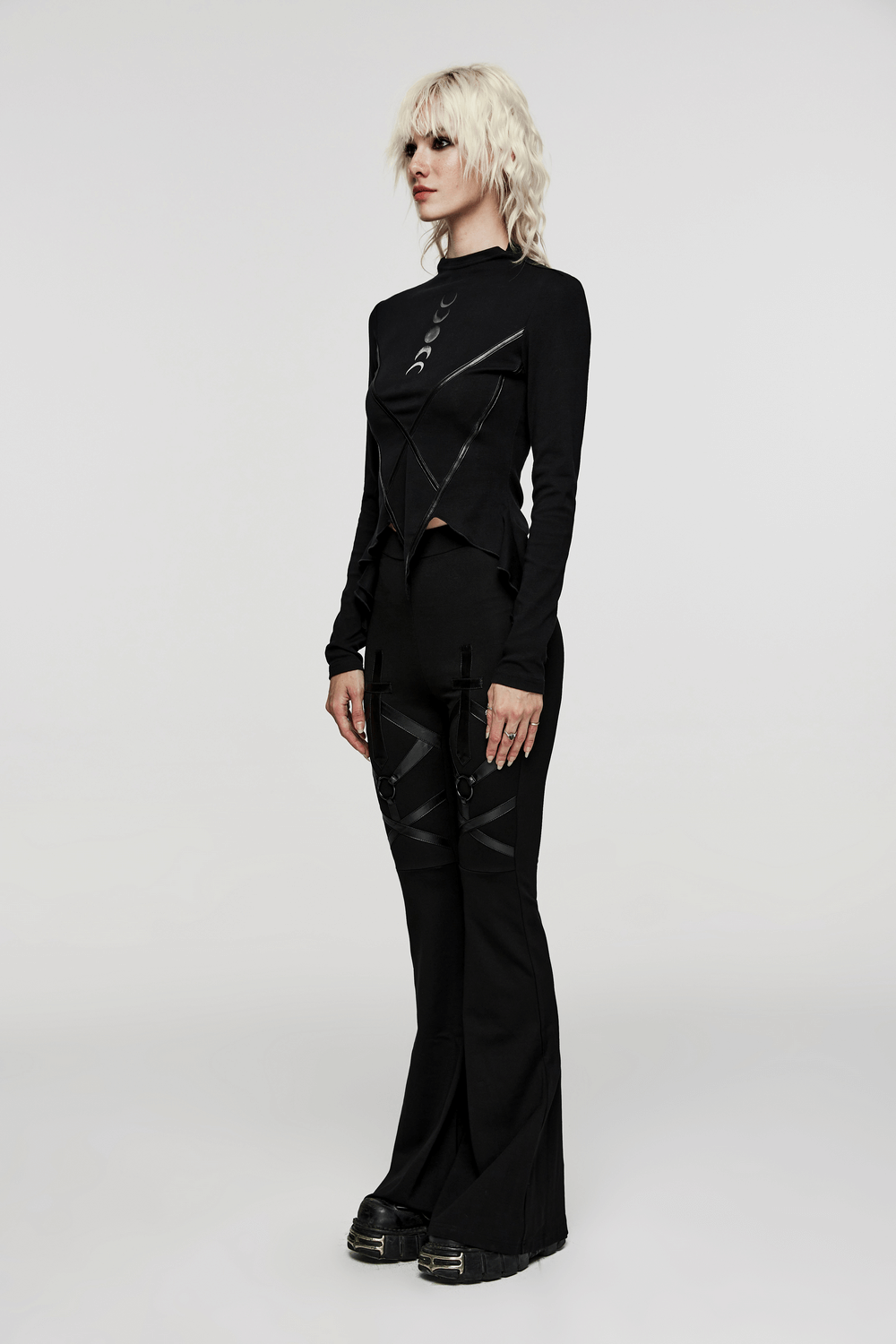 Chic women's gothic ensemble featuring a black knit top with faux leather accents and flared pants, perfect for edgy fashion.