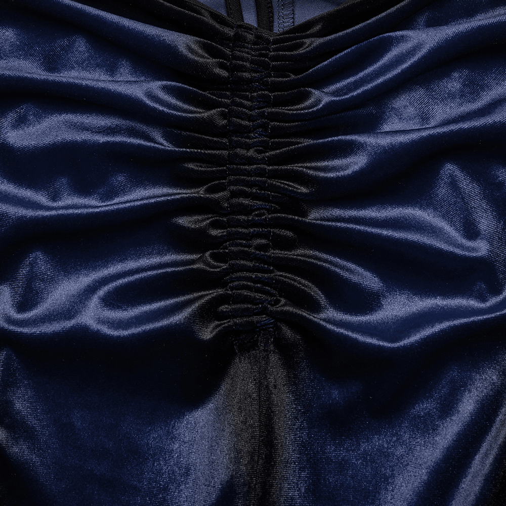 Close-up of women's navy velvet fabric showing ruching detail and black insert for stylish flared pants.