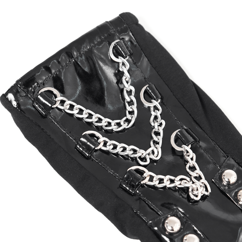 Close-up of women's black patent leather gloves with chains and studs for edgy fashion style.