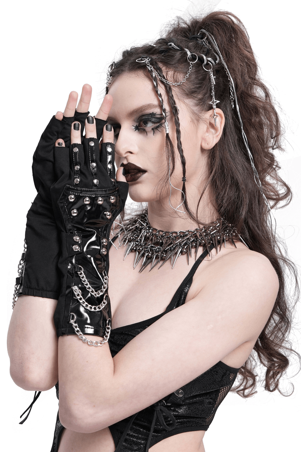 Edgy women's black patent leather gloves with chains and studs, perfect for fashion enthusiasts and themed parties.