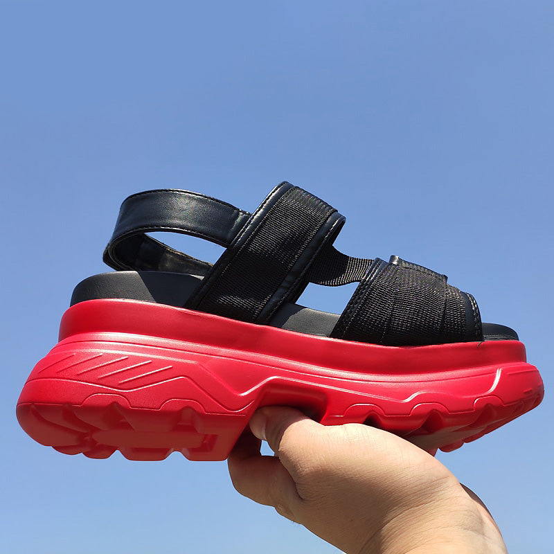 Women's black platform sandals with thick red sole, featuring adjustable straps for a stylish goth look.