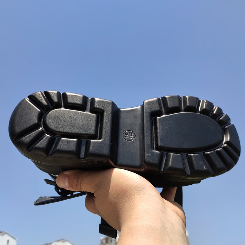 Bottom view of women's platform sandals showcasing thick rubber sole and tread design against a clear blue sky.