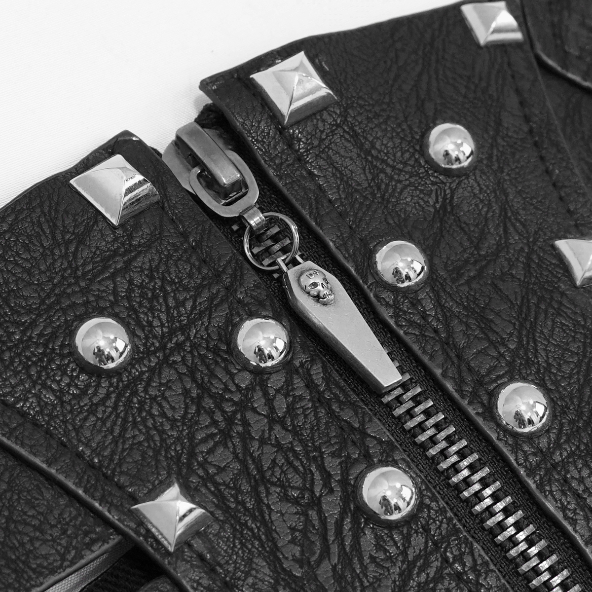 Close-up of black PU leather corset with silver rivets and decorative zipper in gothic style.