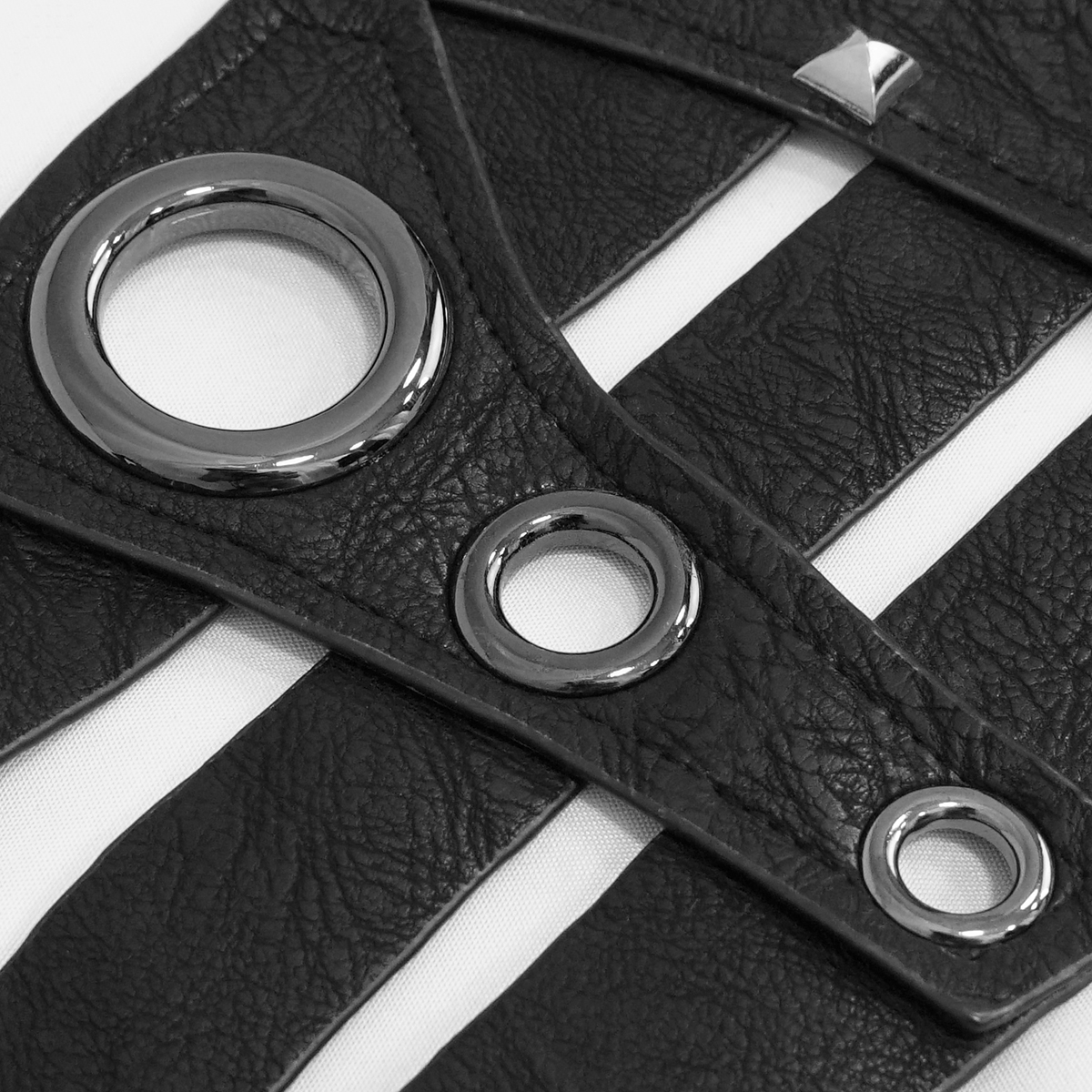 Close-up of black PU leather with silver rivets and rings, highlighting gothic style details for women's belts.