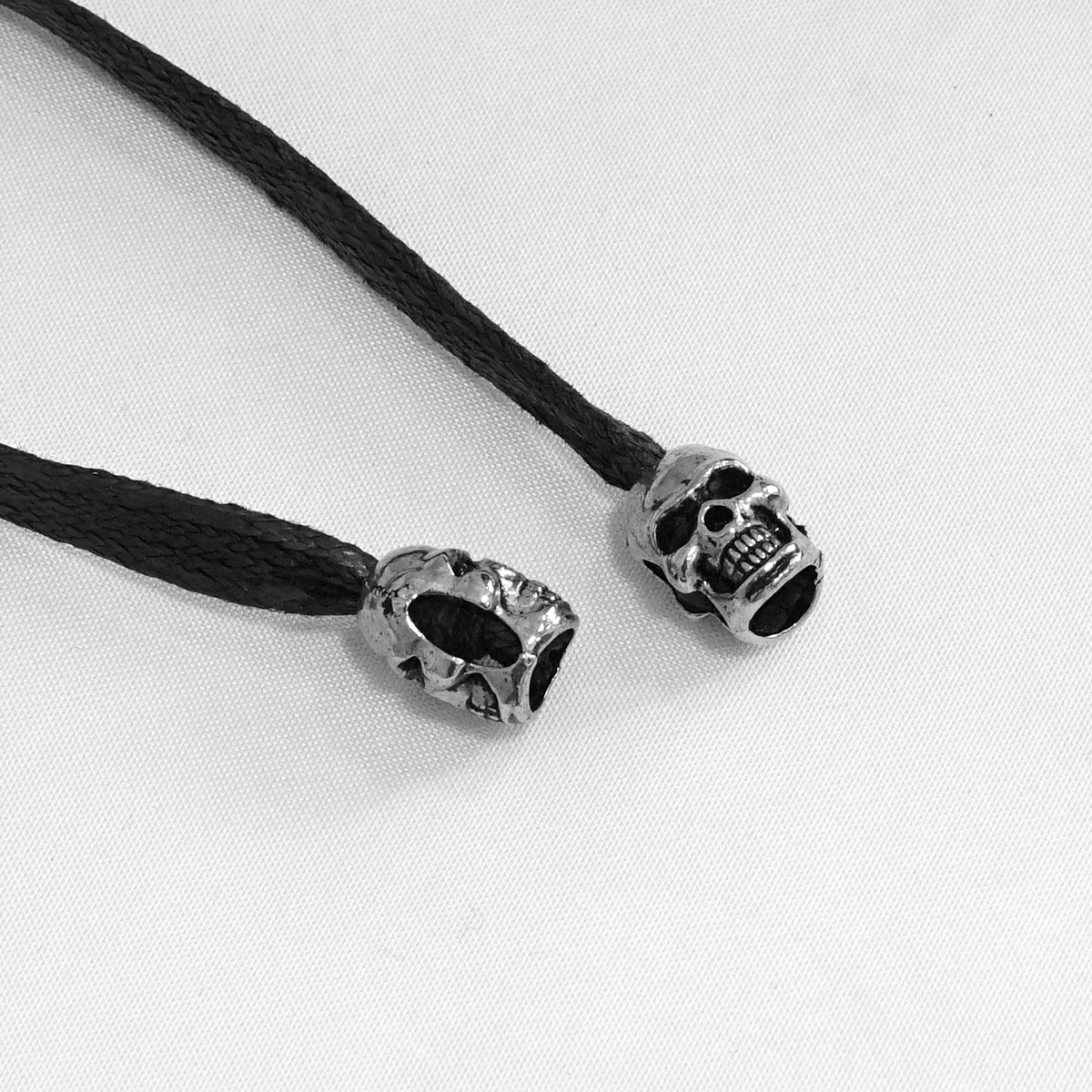 Gothic skull beads on black cords, perfect for adding an edgy touch to your style or accessories.