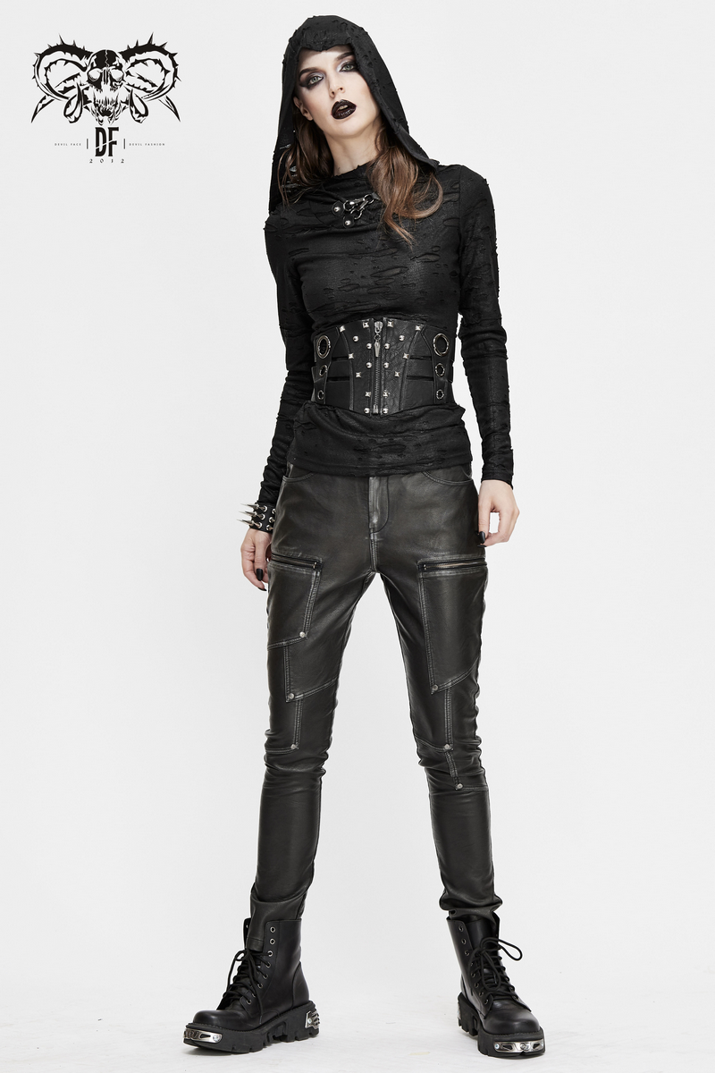 Woman in gothic style outfit featuring a black corset belt with rivets, paired with sleek leather pants and combat boots.