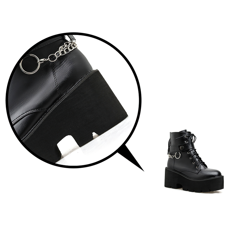 Close-up of women's black PU leather gothic boots with chain and platform sole.