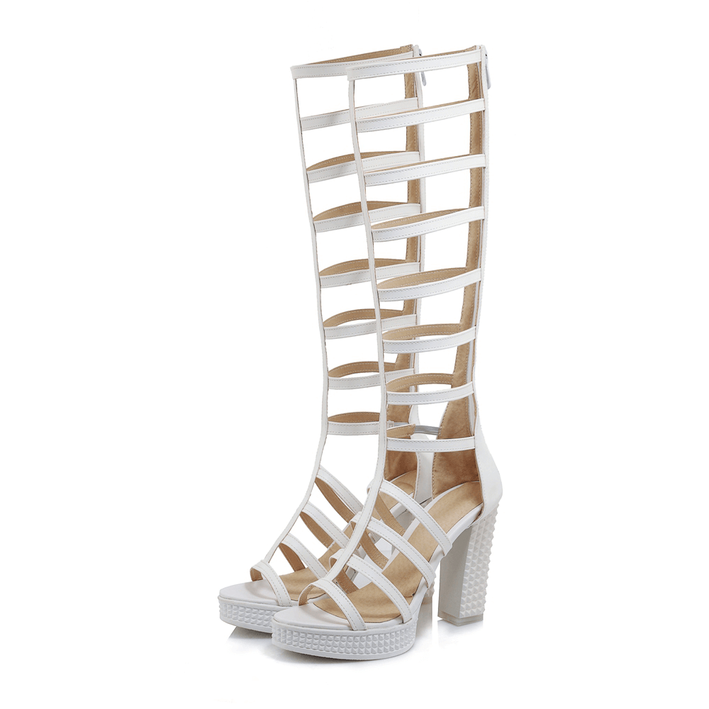 Stylish white knee-high gladiator sandals with strappy design and chunky heel for summer fashion.