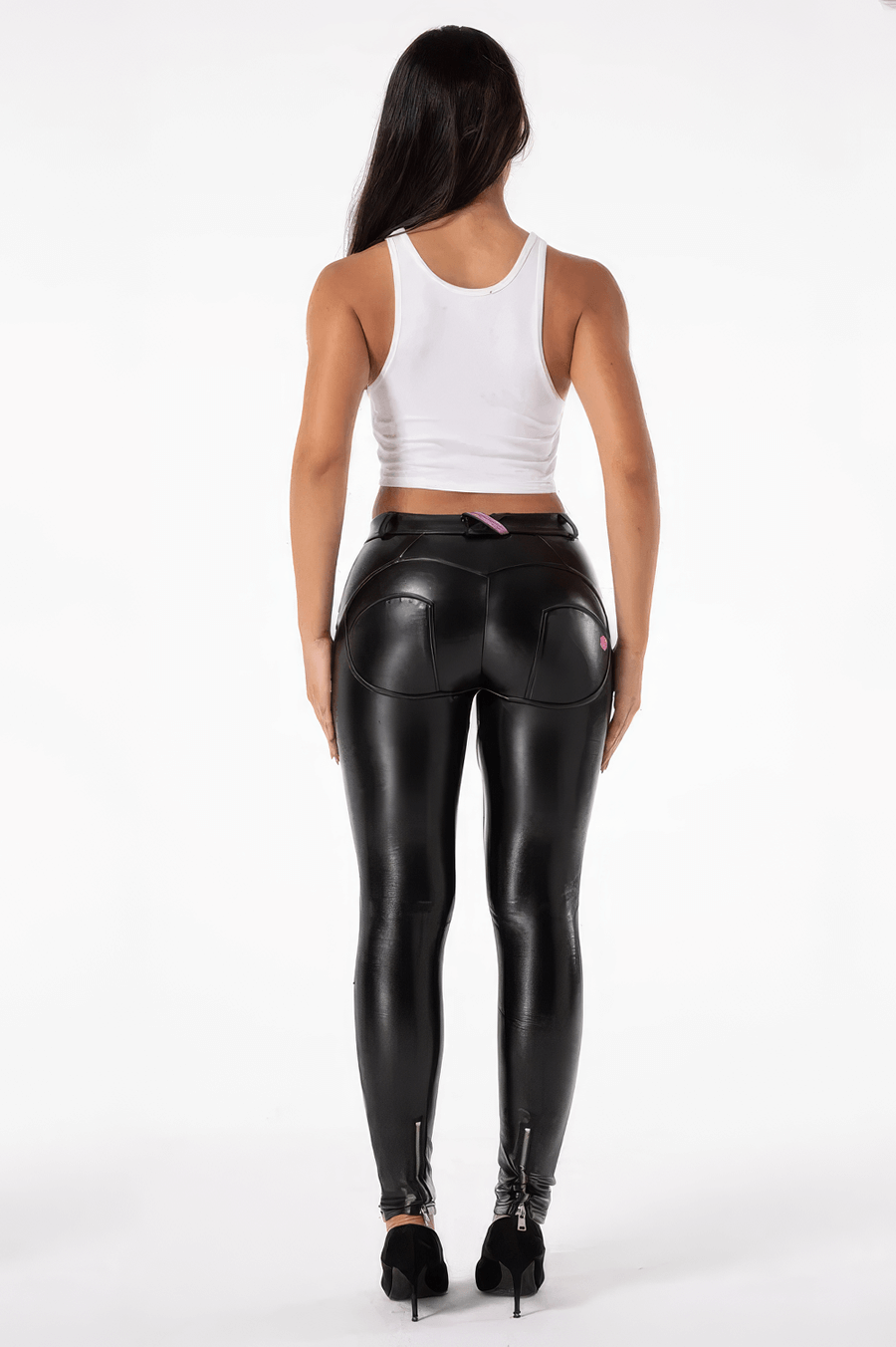 Back view of a woman in skin-tight PU leather biker pants, showcasing a rock style with zippers and a stylish fit.