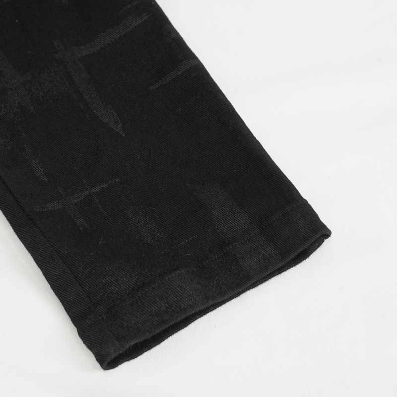 Close-up of the hem of women's punk high-waisted fitted pants with edgy rips and unique patterns.