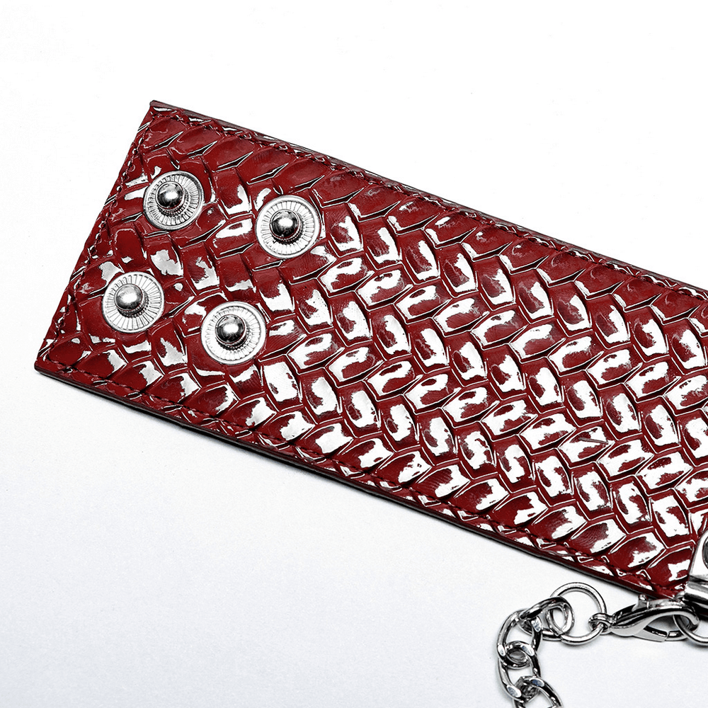 Close-up of red python grain choker with metal spikes and rivets, showcasing edgy fashion details.
