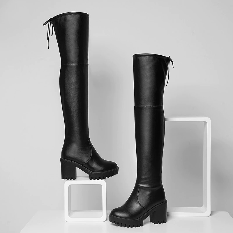 Stylish black thigh-high platform boots with round toes and chunky heels, perfect for trendy casual outfits.