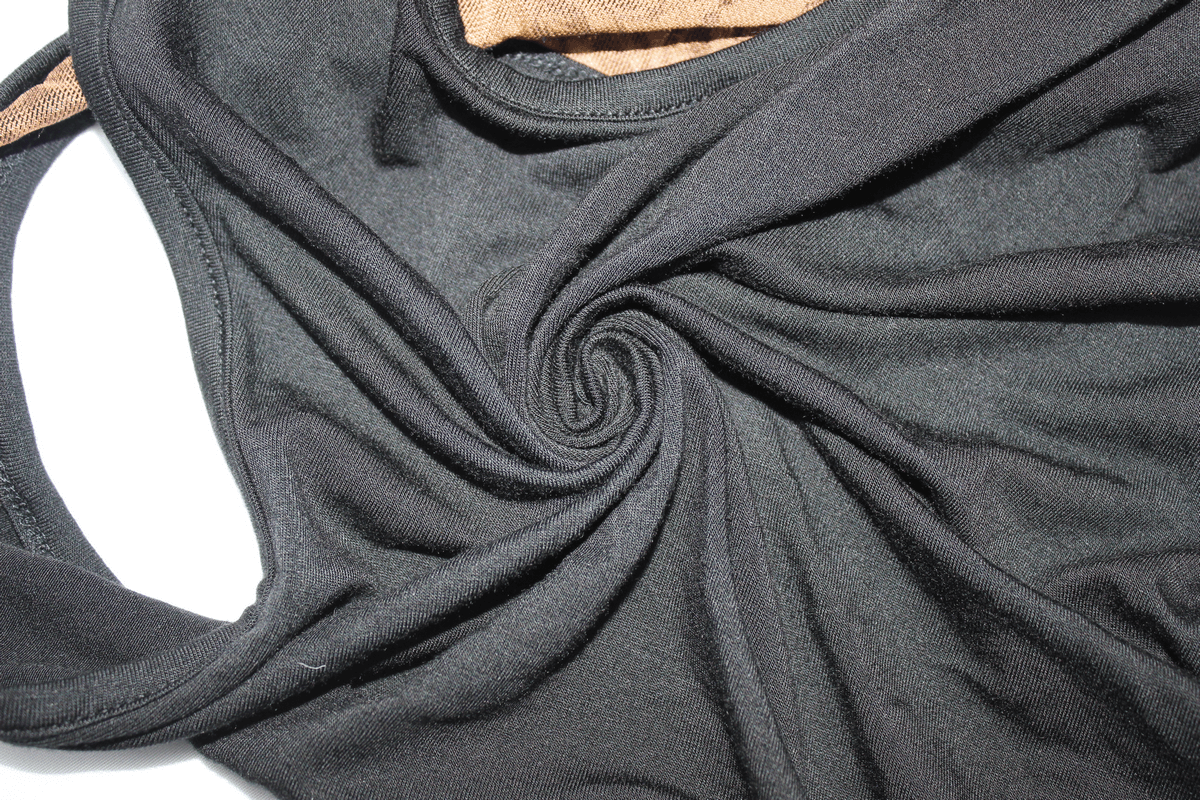 Close-up of black sleeveless dress fabric showcasing a swirling pattern, perfect for gothic vintage style.