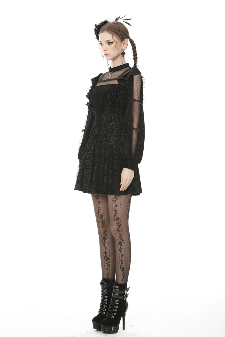 Elegant woman in a vintage-inspired black dress with sheer sleeves, posing stylishly with gothic accessories.