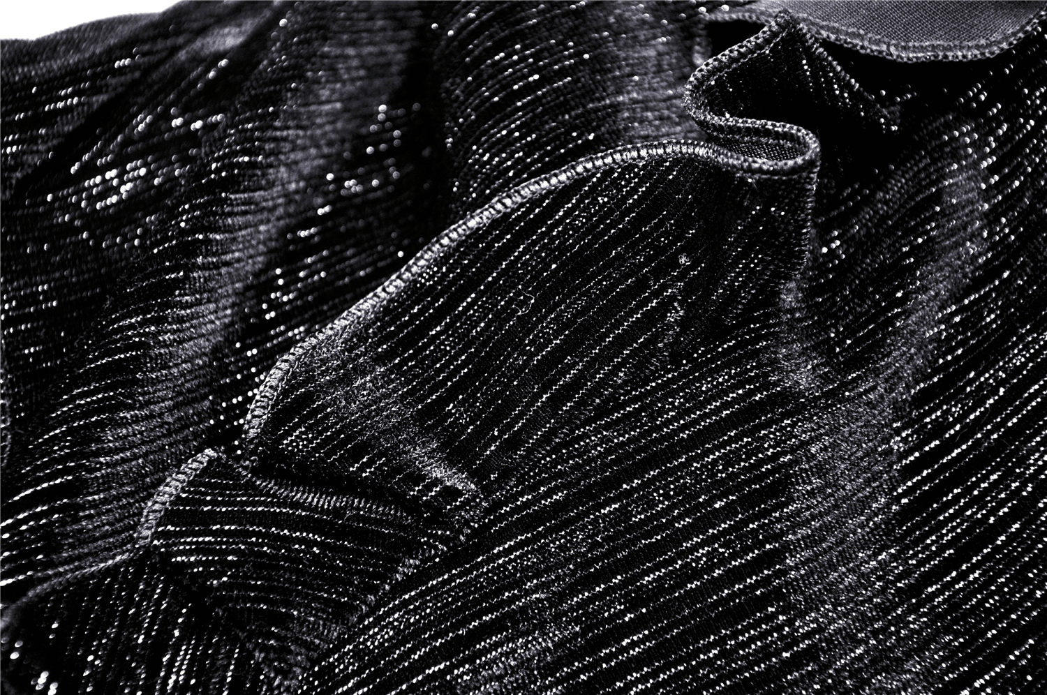 Close-up of luxurious black fabric with shimmering texture, perfect for a vintage-inspired dress or elegant attire.