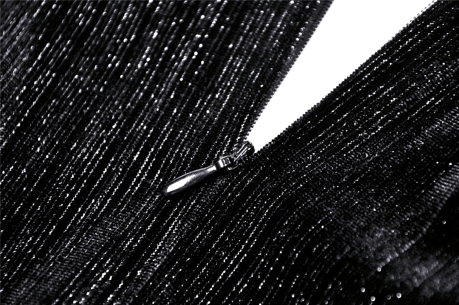 Close-up of the zipper detail on a sleek black dress showcasing shiny fabric texture.