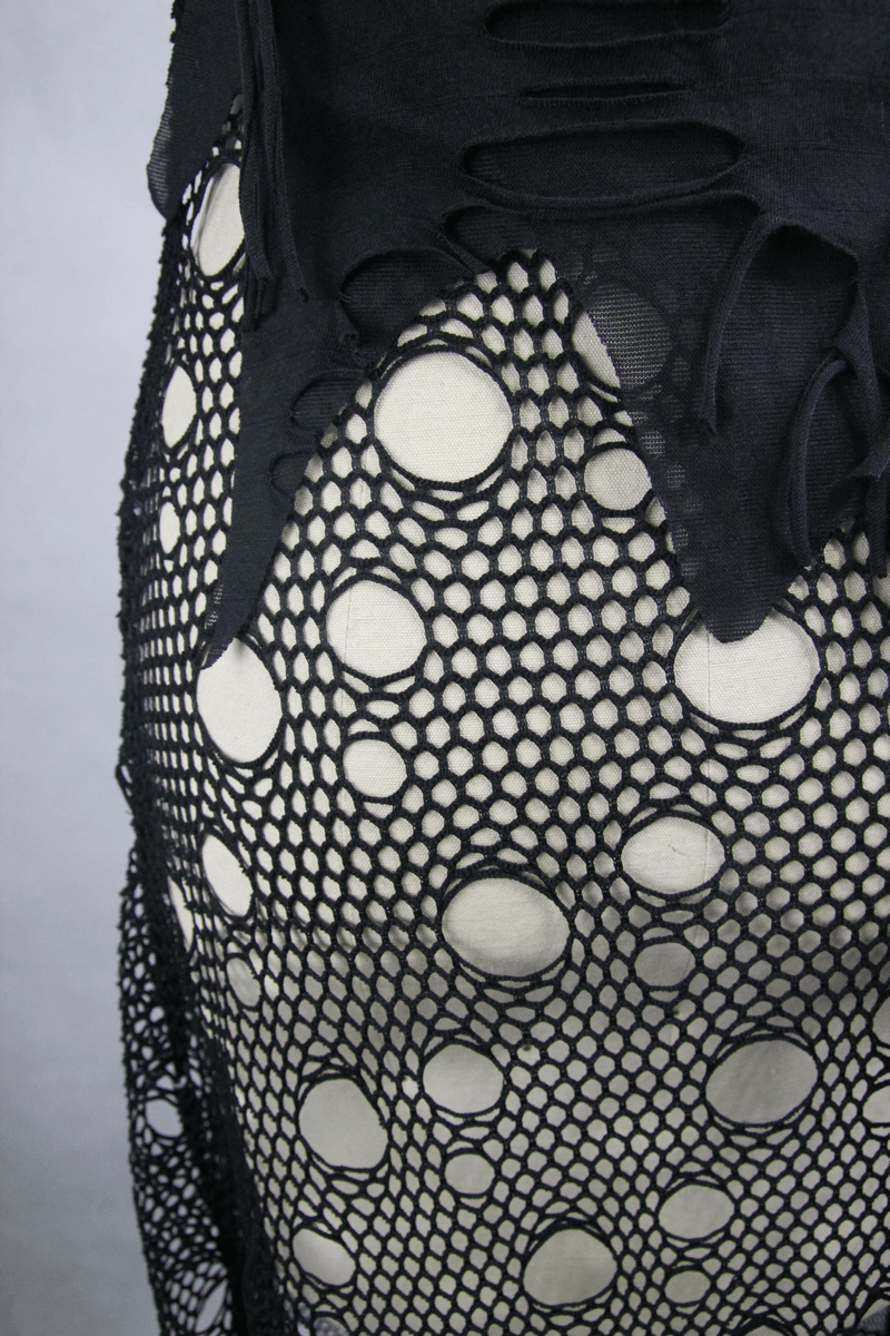 Close-up of a black women's maxi dress with gothic skull pattern and mesh fabric featuring bold circular cutouts.