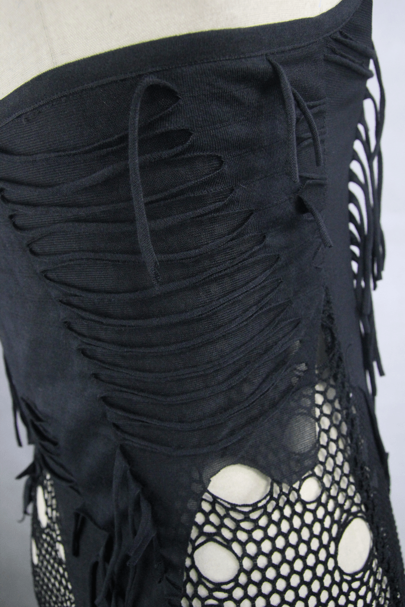 Close-up of black knee-length dress with distressed fabric and mesh inserts, showcasing edgy gothic style details.
