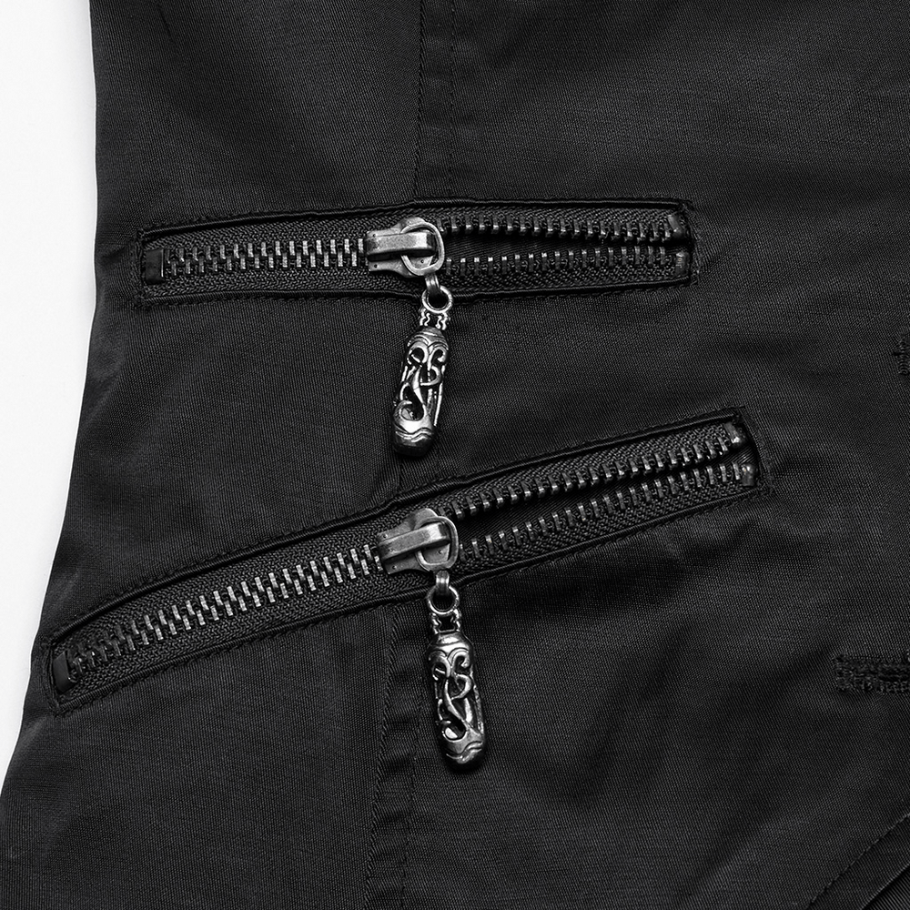 Close-up of black asymmetric waistcoat's stylish double zipper pockets with decorative chain details.