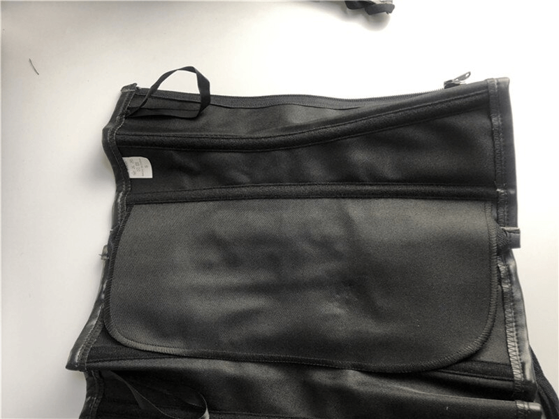 Close-up of a women's steampunk corset featuring a smooth black fabric and zipper detail, showcasing gothic style.