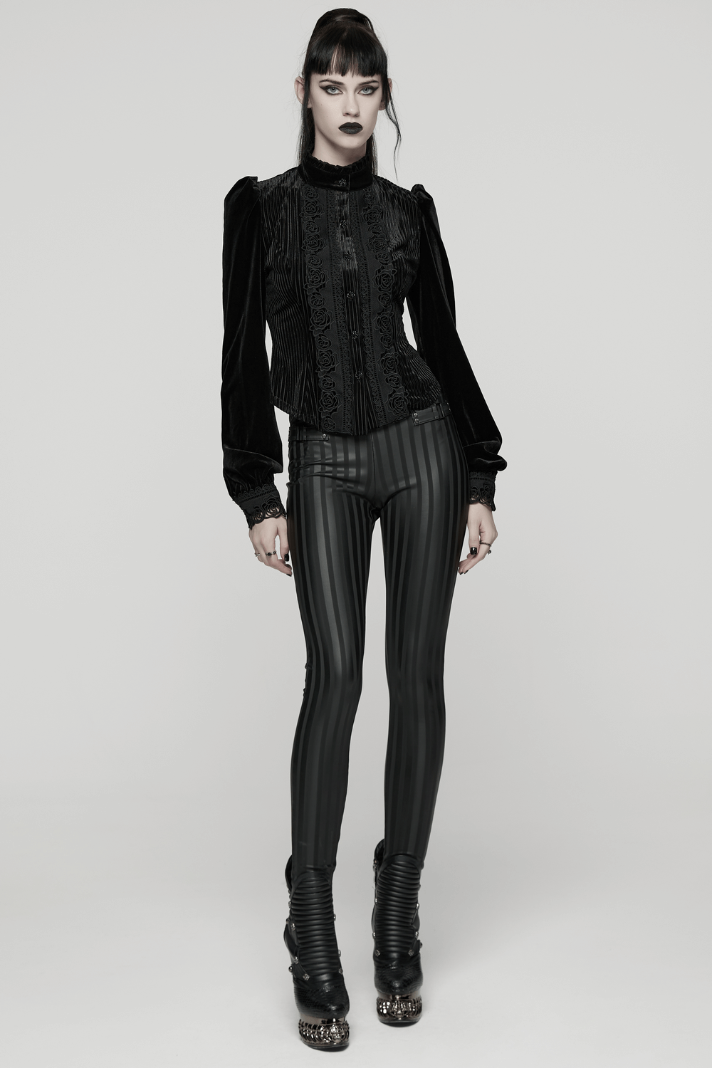 Women's Striped Leggings with Buckle Straps and Pockets paired with a stylish black top and edgy boots.