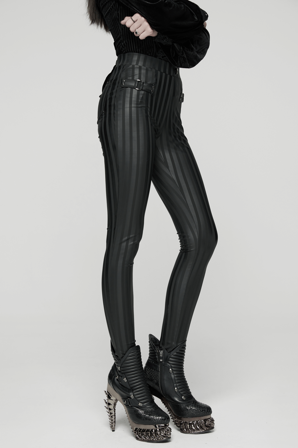 Women's Striped Leggings with Buckle Straps and Pockets worn with edgy boots, featuring sleek stretch fabric and back pockets.