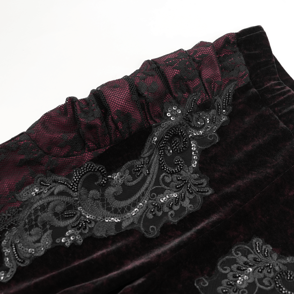Close-up of women's velvet flare pants with lace and embroidered appliques in dark boho style, showcasing elegant detailing.