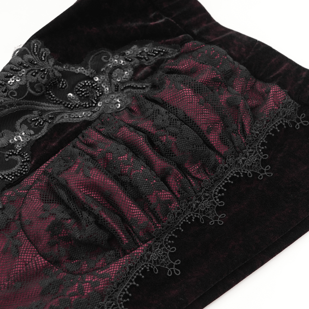 Close-up of women's velvet flare pants featuring intricate black lace and embroidered detail for gothic fashion.