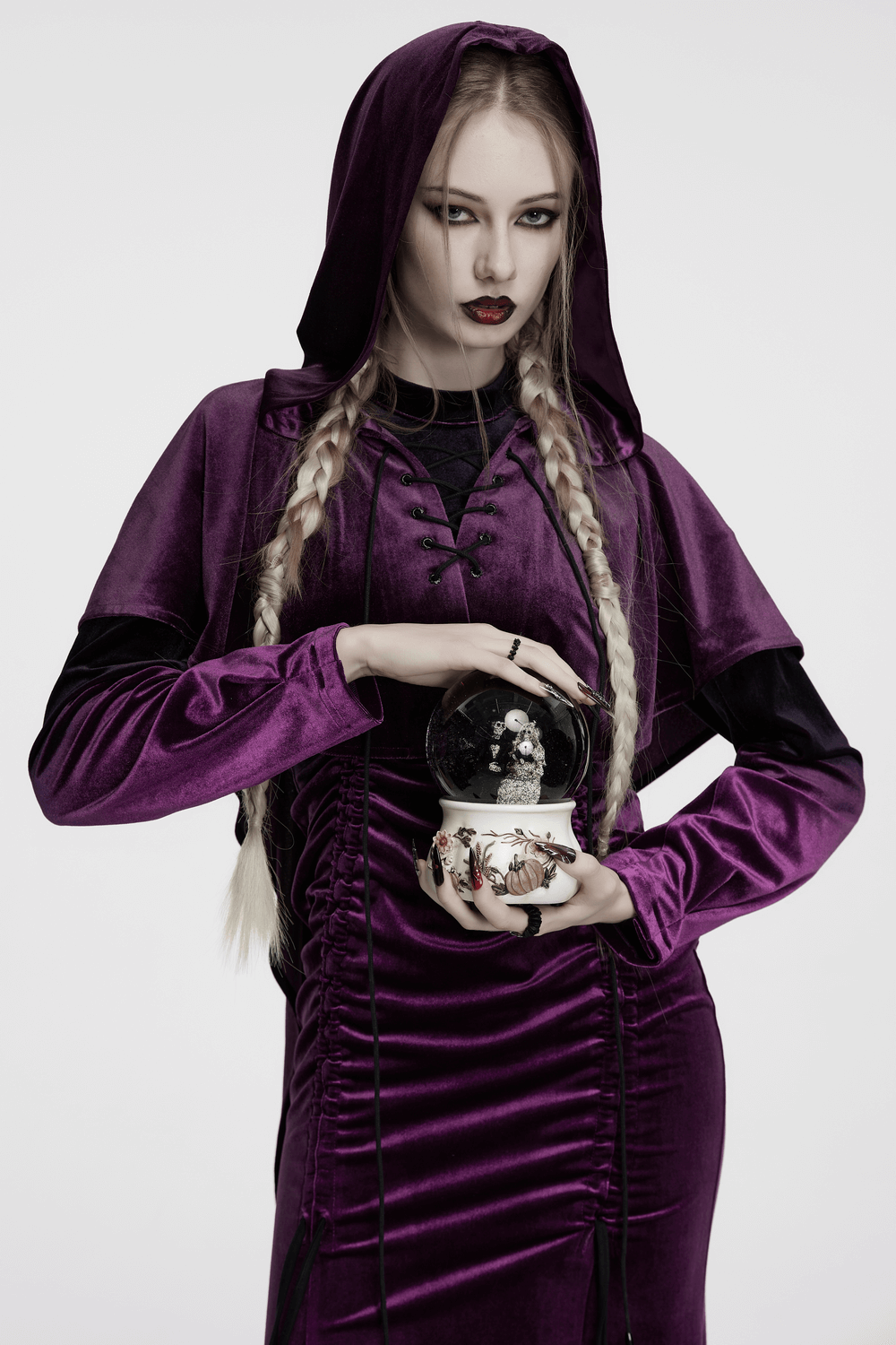 Model wearing women's purple velvet hooded cape with drawstring front, holding a snow globe for a gothic fantasy look.