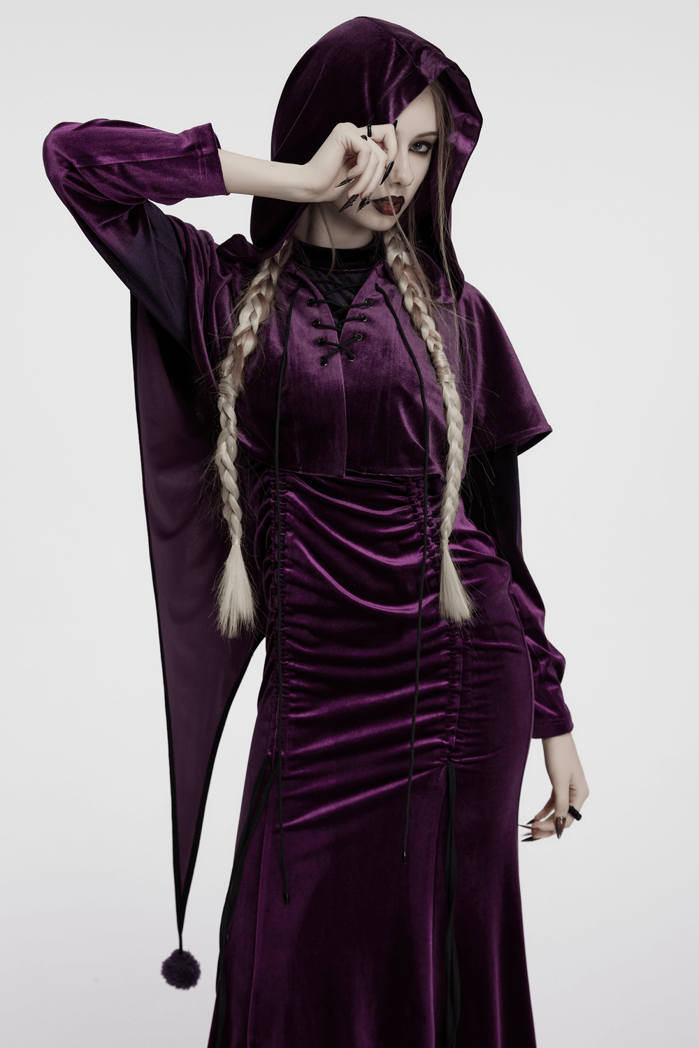 Model wearing a women's purple velvet hooded cape with drawstring front and fur ball tips, exuding an elven-inspired style.