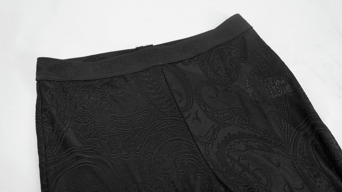 Close-up of women's black vintage gothic flared trousers featuring intricate lace trim and stylish detail.
