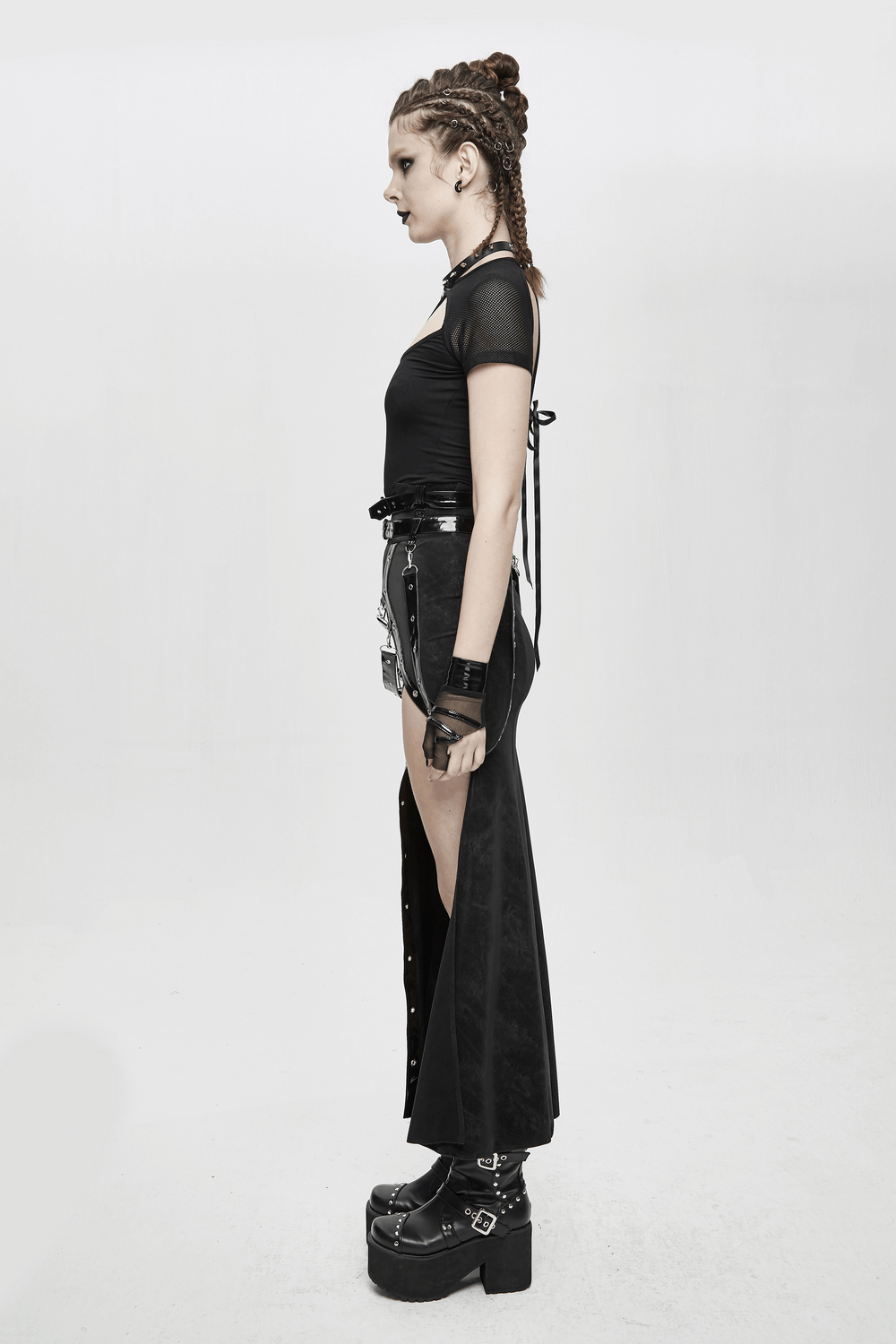 Side view of a model wearing a women's vintage long skirt, showcasing rivets, straps, and a punk aesthetic.