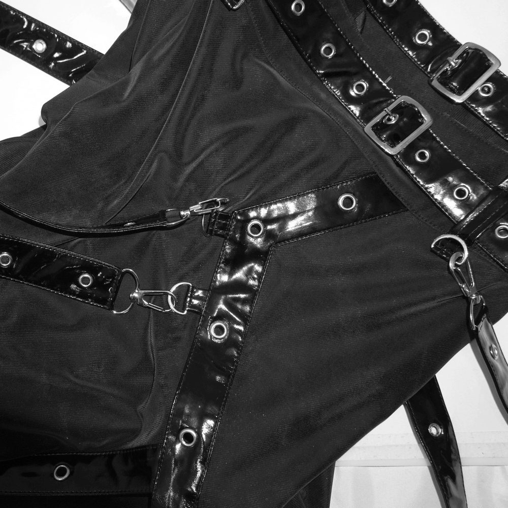 Close-up of black vintage long skirt with shiny rivets and straps; perfect for steampunk and grunge fashion.