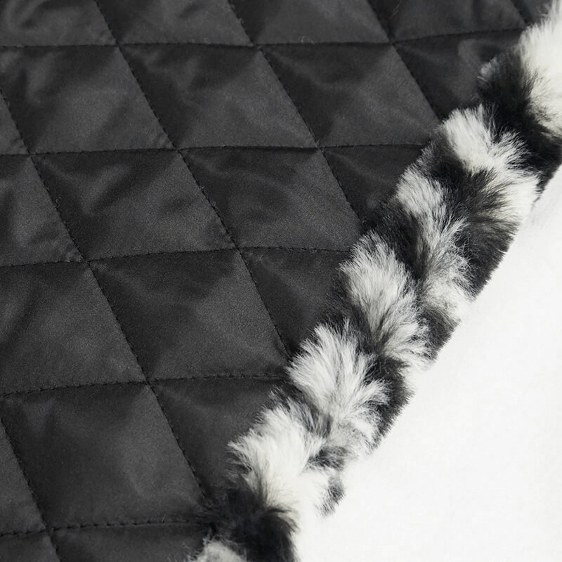 Close-up of women's zebra-stripe jacket showing quilted fabric and faux fur trim for a stylish look.