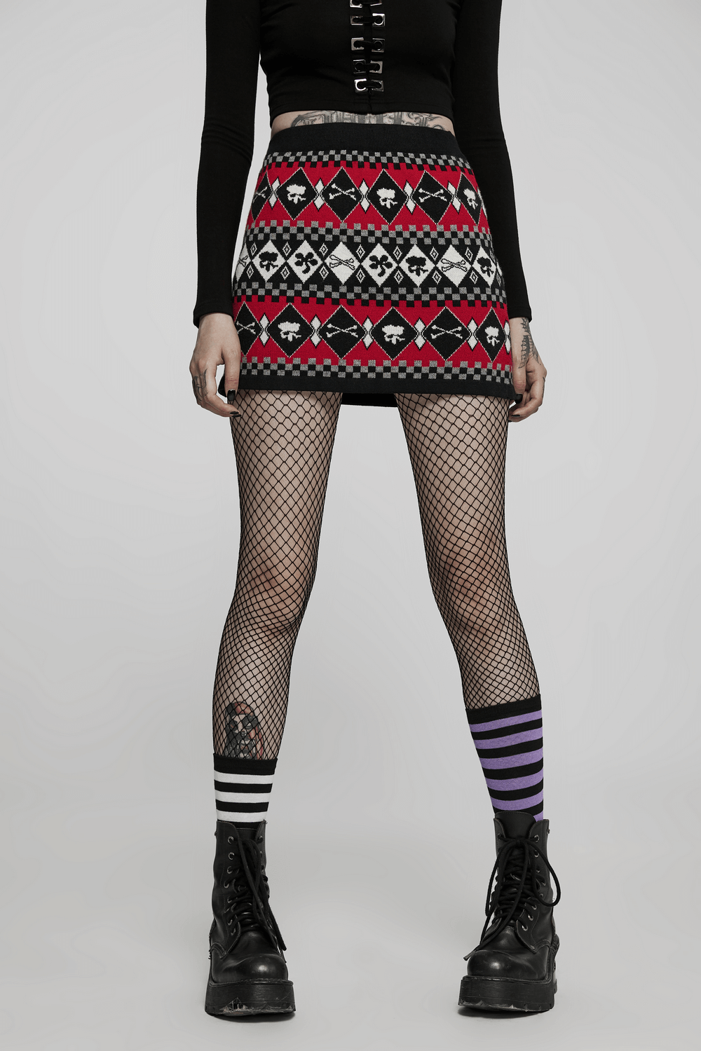 Wool-blend knit skirt with geometric skull design, styled with fishnet tights and combat boots for a trendy look.