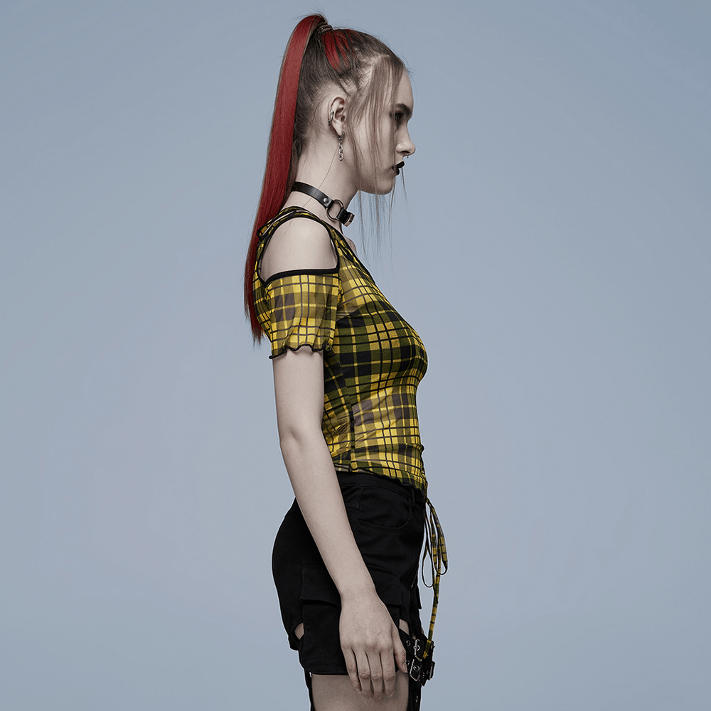 Punk style woman in yellow plaid mesh t-shirt with asymmetric neckline and black trim, showcasing edgy fashion.